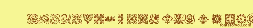 フォントPtornament – 茶色の文字が黄色の背景にあります。