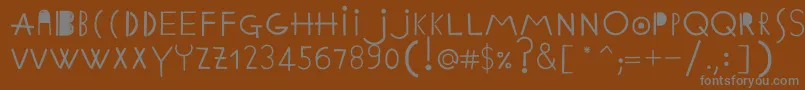 EthnicabcRegularWebfont-fontti – harmaat kirjasimet ruskealla taustalla