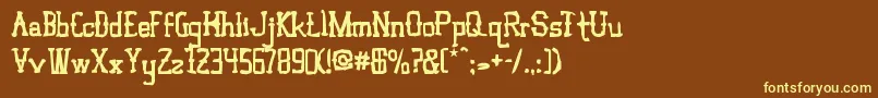 VloderstoneAntique3-fontti – keltaiset fontit ruskealla taustalla