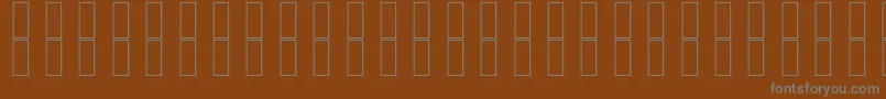 SkrHead2Outlined-fontti – harmaat kirjasimet ruskealla taustalla