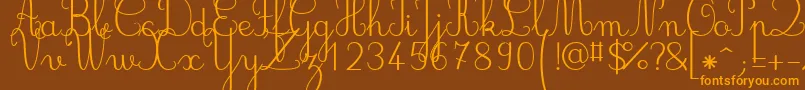 フォントJbcursive – オレンジ色の文字が茶色の背景にあります。