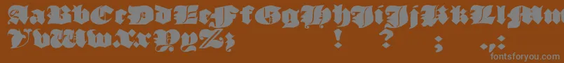 JmhMorenetaDivine-fontti – harmaat kirjasimet ruskealla taustalla