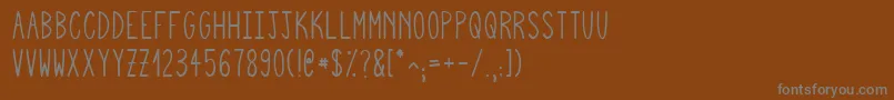 Czcionka Squigglyasta – szare czcionki na brązowym tle
