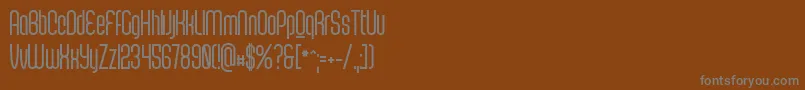 ScantypeboldPersonal-fontti – harmaat kirjasimet ruskealla taustalla