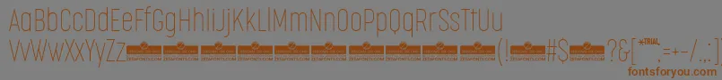 Czcionka CocogooseCompressedThinTrial – brązowe czcionki na szarym tle