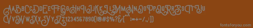 TriumphWheelsRough-fontti – harmaat kirjasimet ruskealla taustalla