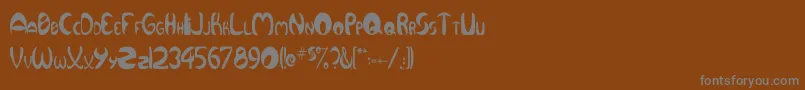 QurveThin-fontti – harmaat kirjasimet ruskealla taustalla