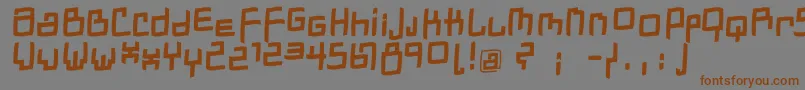 フォントDadastracesfreeshapesBolditalic – 茶色の文字が灰色の背景にあります。