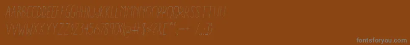 AracneCondensedLightItalic-fontti – harmaat kirjasimet ruskealla taustalla