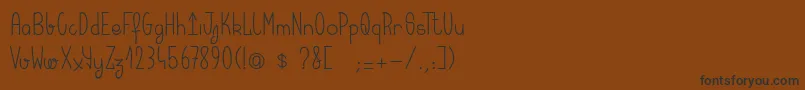 フォントKeralaquest – 黒い文字が茶色の背景にあります